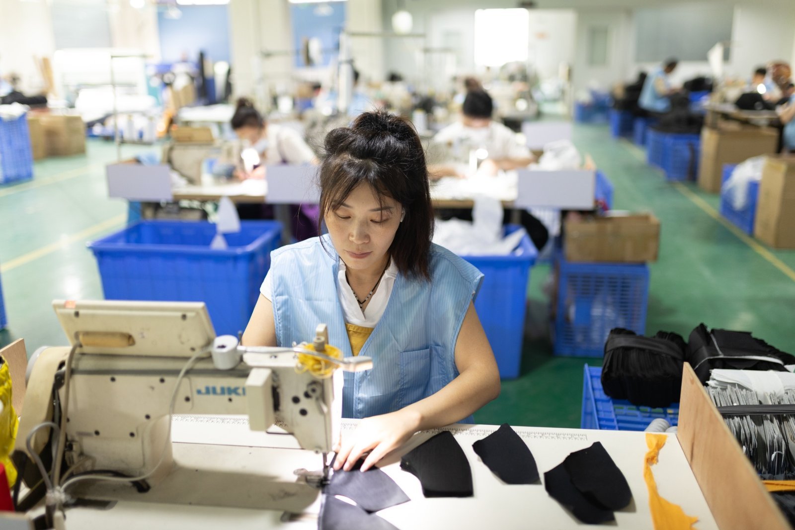 Workers assembling custom performance caps on a real production line